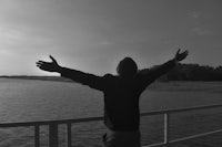 a man standing on a dock with his arms outstretched